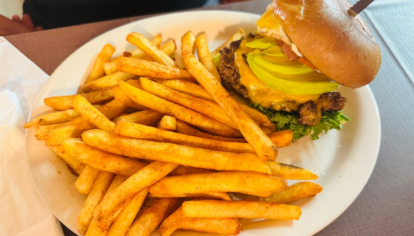 Sunrise Burger stacked with bacon, avocado and melted cheddar beside a heap of seasoned fries